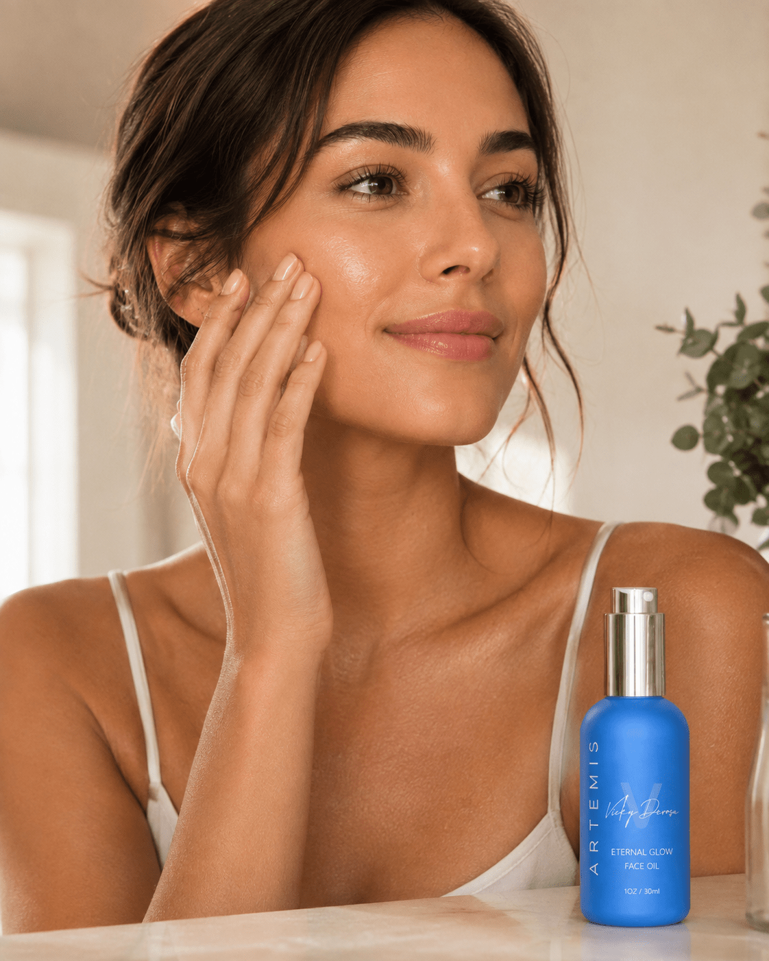 Woman applying Artemis face oil to her cheek